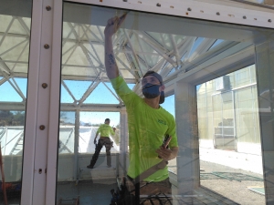 Greg and Tristen Spencer applying window tint to SAM at Biosphere 2