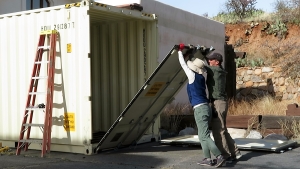 Cooleen Cooley, Kai Staats removing door from shipping container, SAM at Biosphere 2