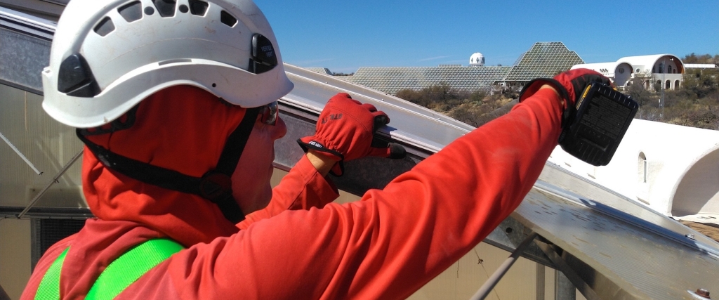 Kai Staats removing an old panel from the Mars yard roof at SAM, Biosphere 2