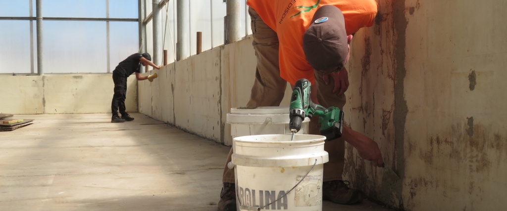 Matthias Beach and Tasha Coelho apply stucco patch to the Mars yard walls at SAM, Biosphere 2