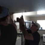 John Z. and Luna Powell securing FRP to the interior of the crew quarters to workshop bridge at SAM, Biosphere 2