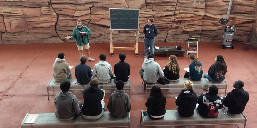 A visiting school attending a program in the SAM Mars yard with SAM team members Jacob Ball and Luna Powell